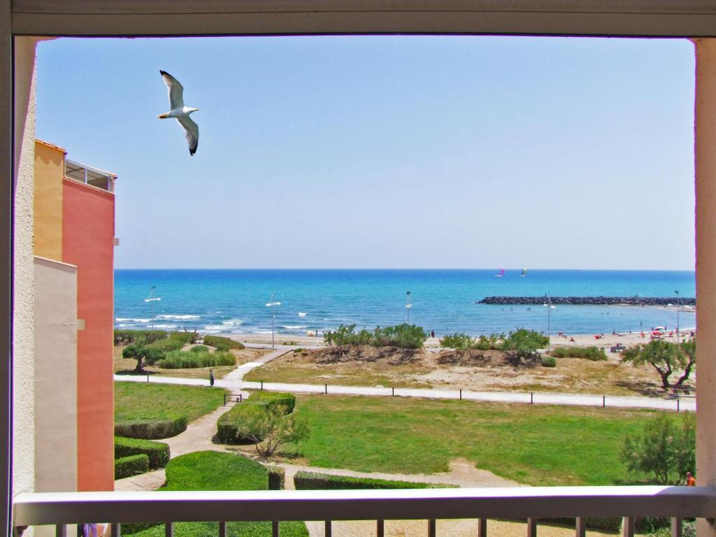 un uccello che vola sull'oceano da un balcone di Vue mer à la plage du Môle - Clim - Fibre Wifi a Cap d'Agde
