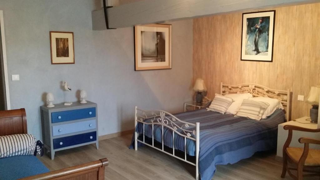 ein Schlafzimmer mit einem Bett, einer Kommode und einem Tisch in der Unterkunft gîte du luquet in Chazelles
