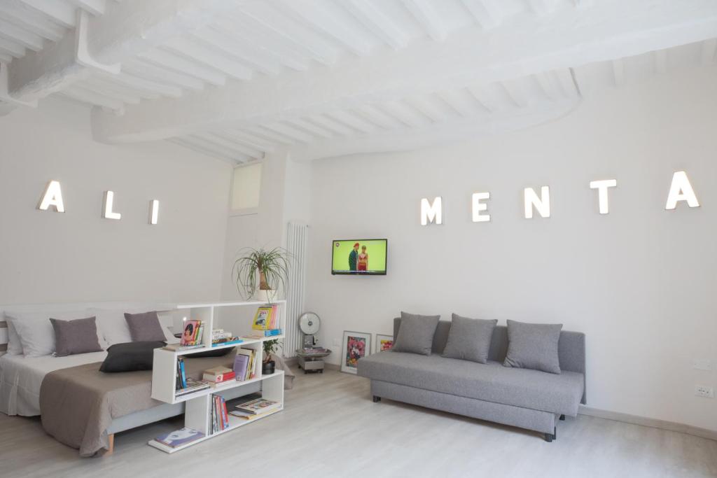 ein Wohnzimmer mit 2 Sofas und einer weißen Wand in der Unterkunft ALIMENTA open space city center in Lucca