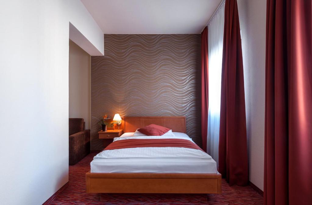 Postel nebo postele na pokoji v ubytování Club Hotel Cortina