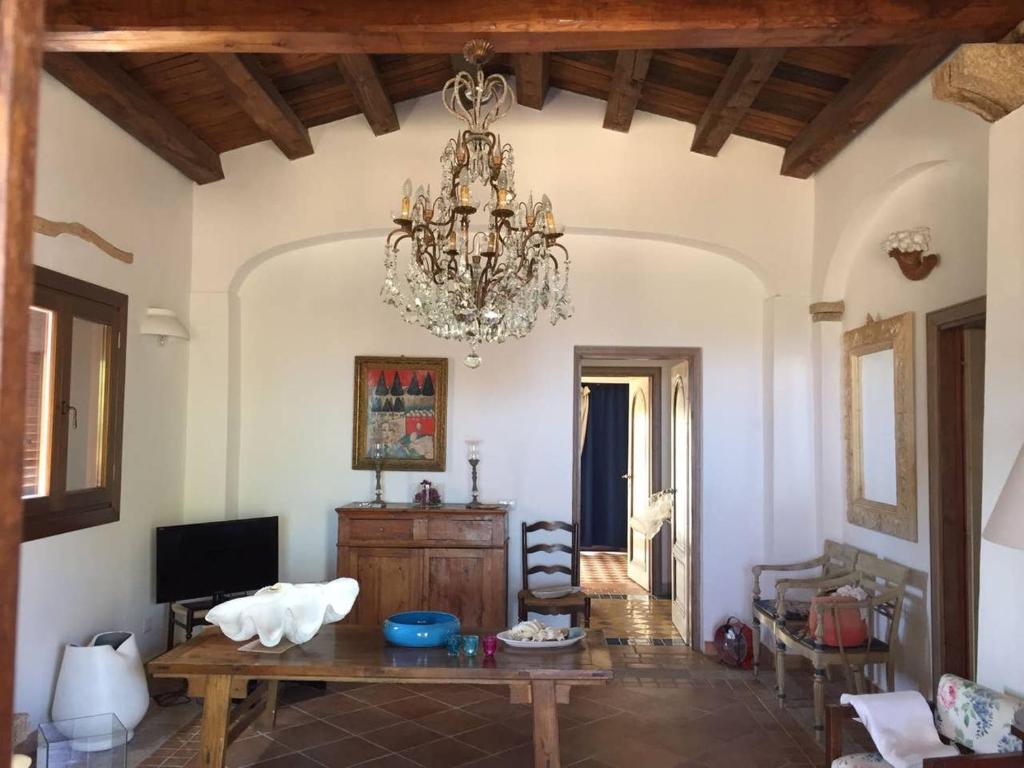 a living room with a chandelier and a table at Villa Smeralda in Olbia