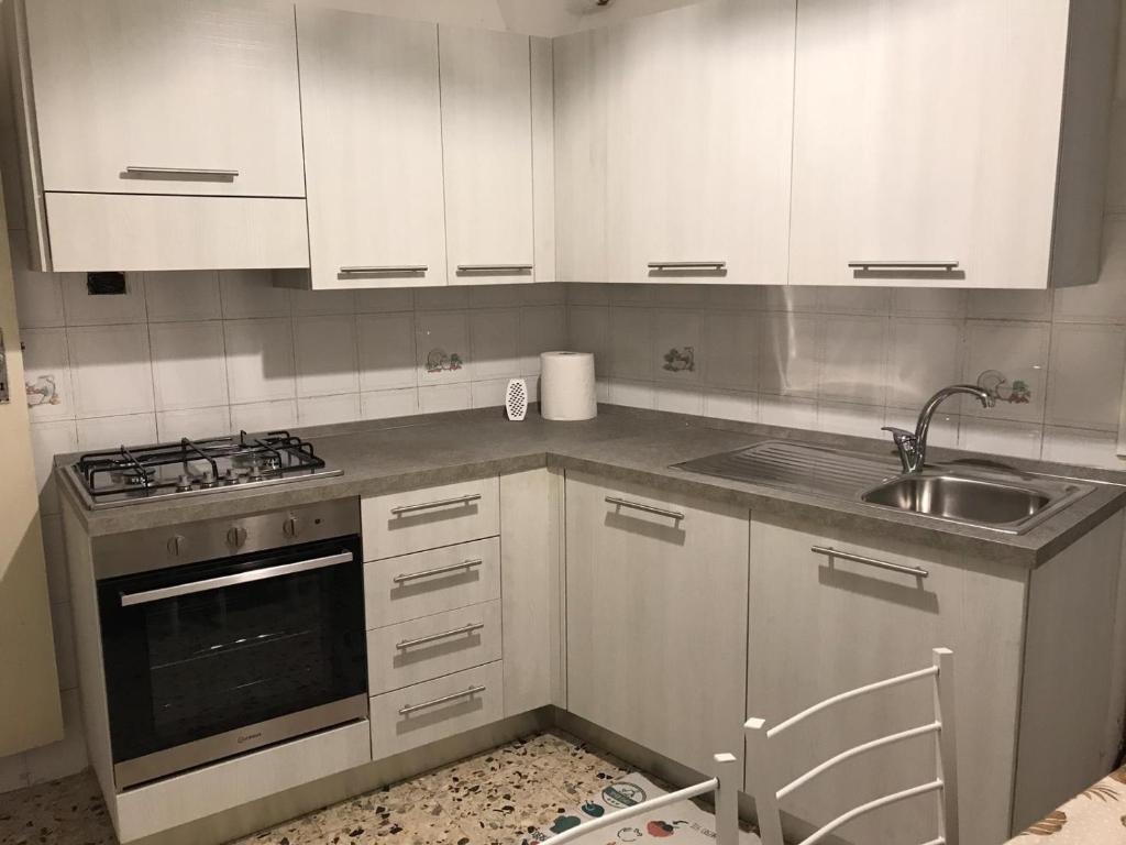 a kitchen with white cabinets and a sink at A’ ca’ de Giuli’ in Badalucco
