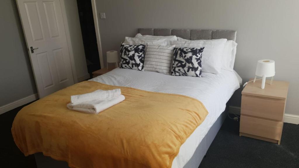 a bedroom with a bed with two towels on it at Gateshead's Amethyst 3 Bedroom Apt, Sleeps 6 Guests in Gateshead