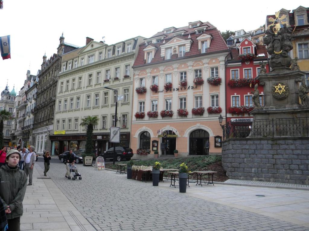 a street with buildings and people walking down a street at U Tří jehňátek in Karlovy Vary