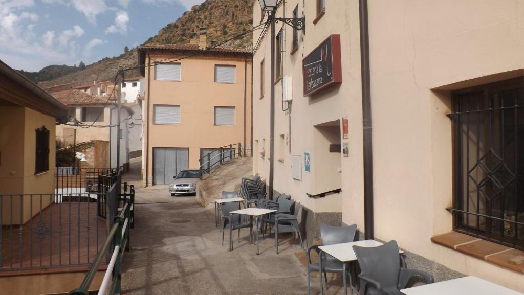 a patio with tables and chairs on a street at La Barbacana in Tramacastiel