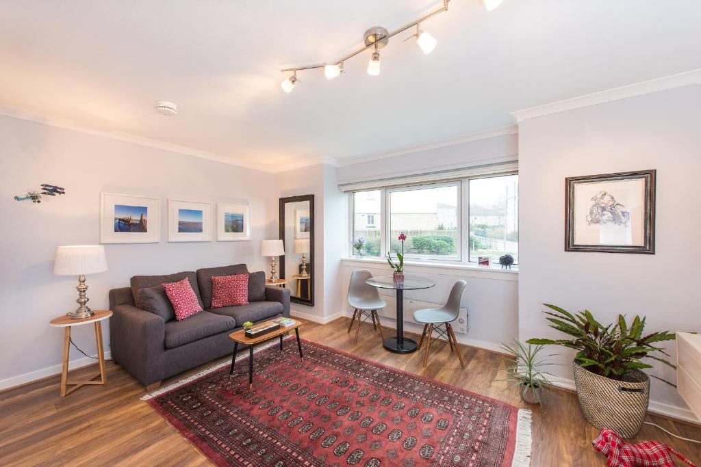 a living room with a couch and a table at Scottish Stays - The Allanfield Apartment in Edinburgh