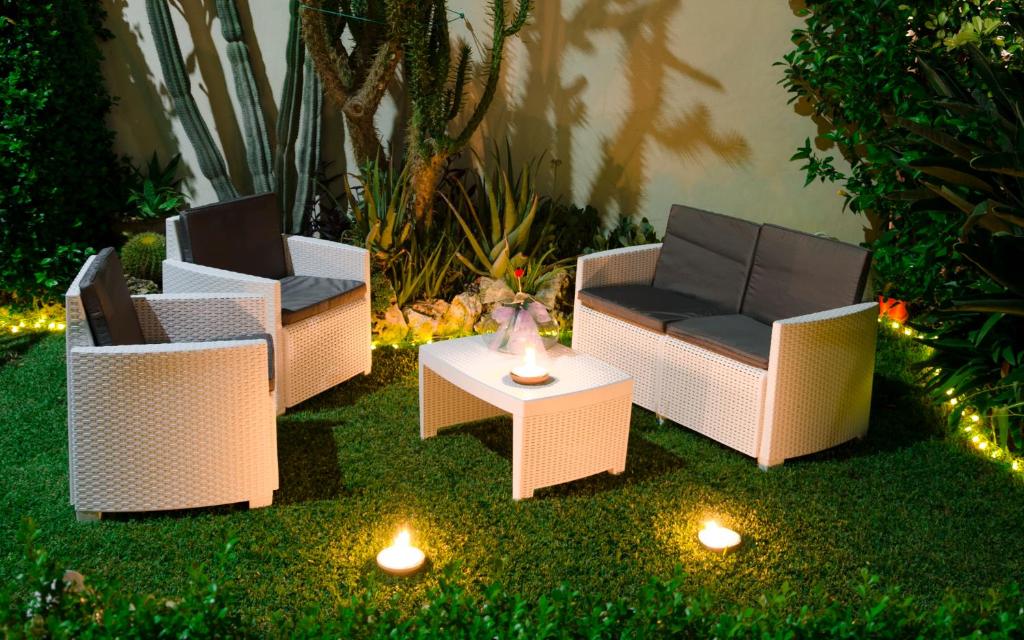 4 sillas y una mesa con luces en un patio en Merlhome en Fondi