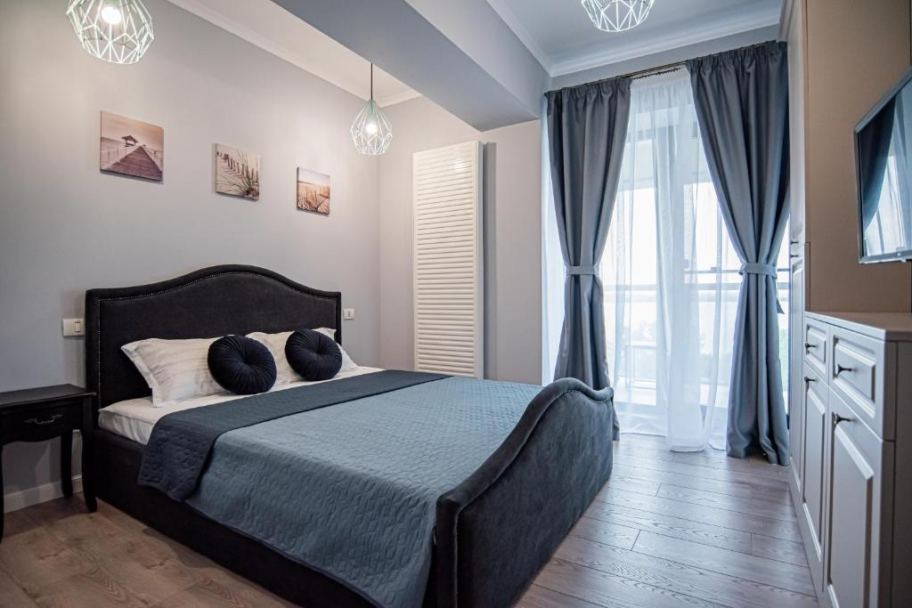 ein Schlafzimmer mit einem Bett mit zwei Kissen darauf in der Unterkunft ByTheSea Superior Apartments in Mamaia