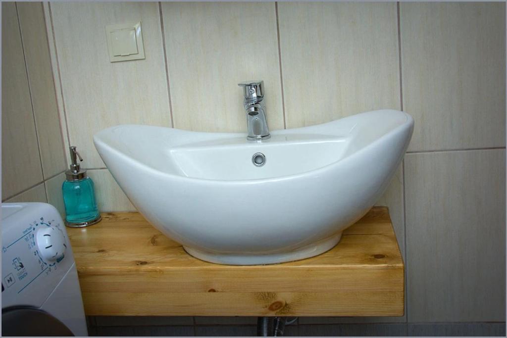 biała umywalka na drewnianym stojaku w łazience w obiekcie Quiet Urban Studio with Private Backyard w Salonikach
