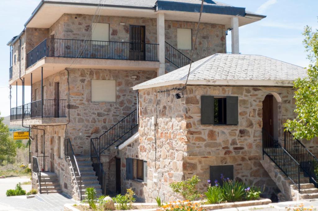 een oud stenen huis met een veranda en een balkon bij Hostal La Majada in Castellanos