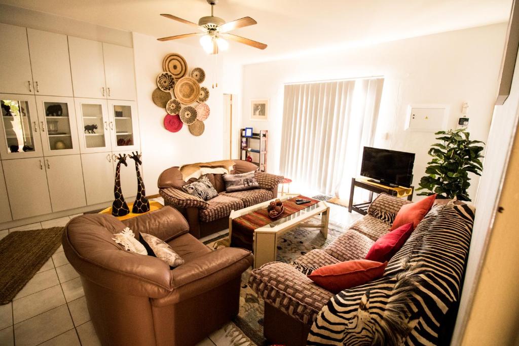 a living room with two couches and a zebra print couch at John-Lou's One-bedroom Apartment in Windhoek