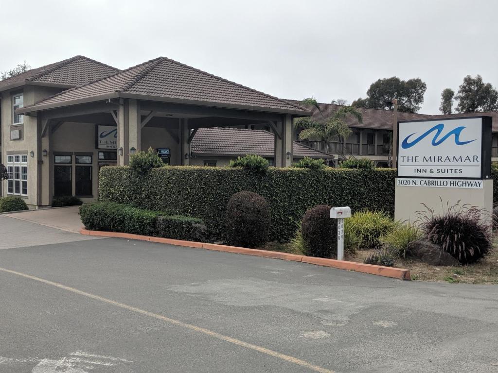 a building with a sign in front of a building at The Miramar Inn & Suites in Half Moon Bay