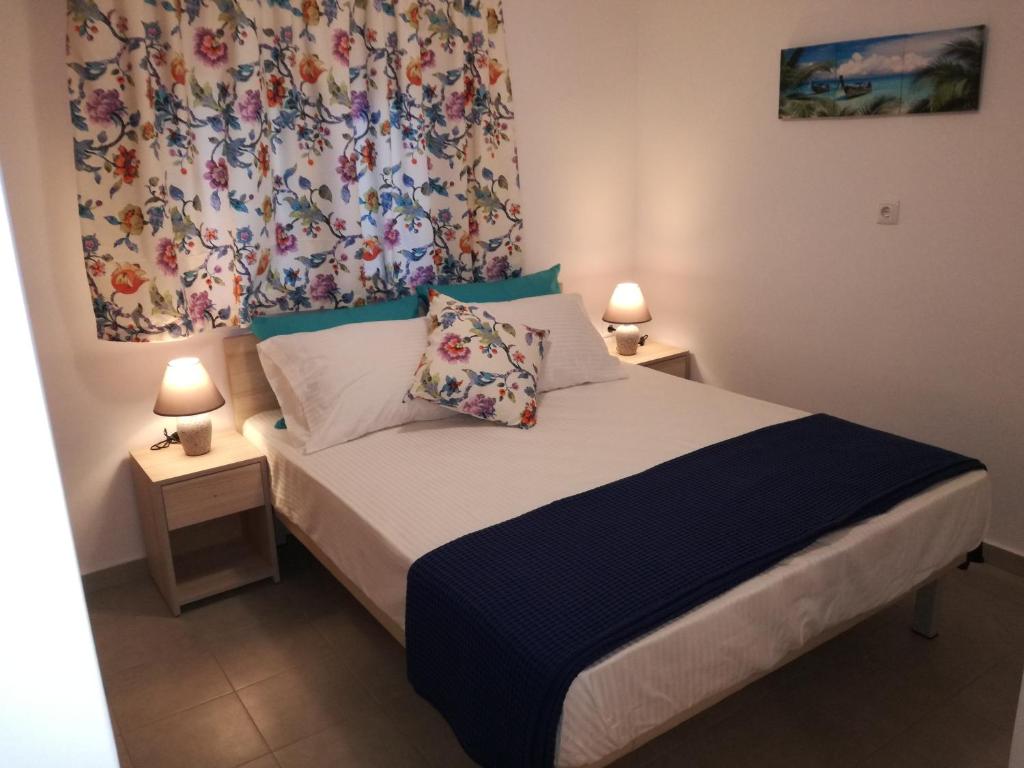 een kleine slaapkamer met een bed met 2 lampen bij Maria's Home in Kavala