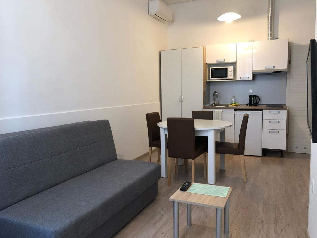 a living room with a couch and a table and a kitchen at Apartments & Rooms Nardin in Izola