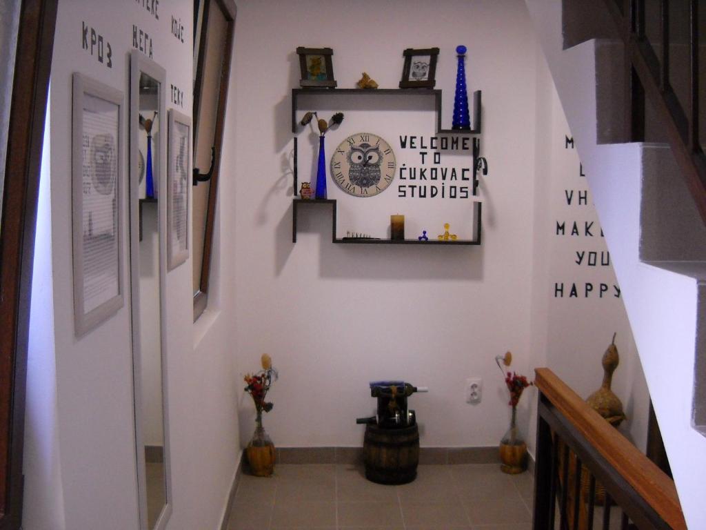 a hallway with white walls and a staircase with pictures on the wall at Ćukovac studios in Belgrade
