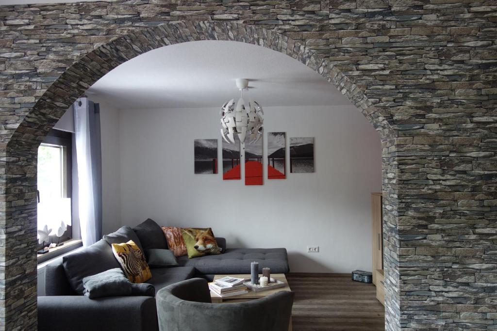 un soggiorno con divano e muro di mattoni di Ferienhaus Rurperle a Nideggen