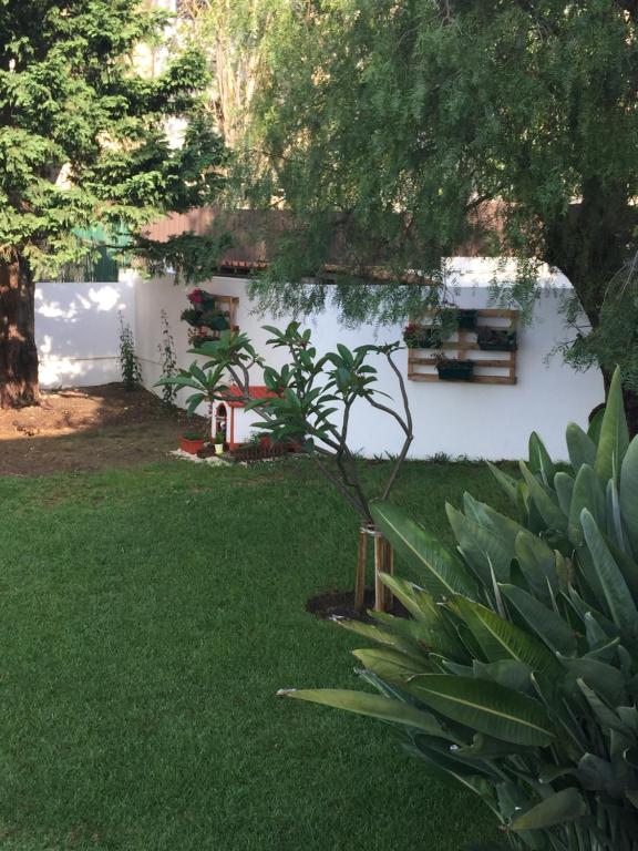 a yard with green grass and a white building at Paradise Suites in Carcavelos