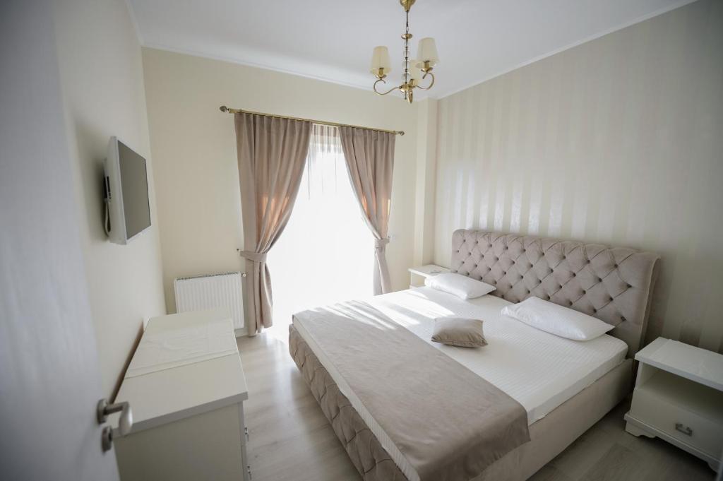 a bedroom with a white bed with a large window at Complex Bavaro in Mamaia Sat/Năvodari