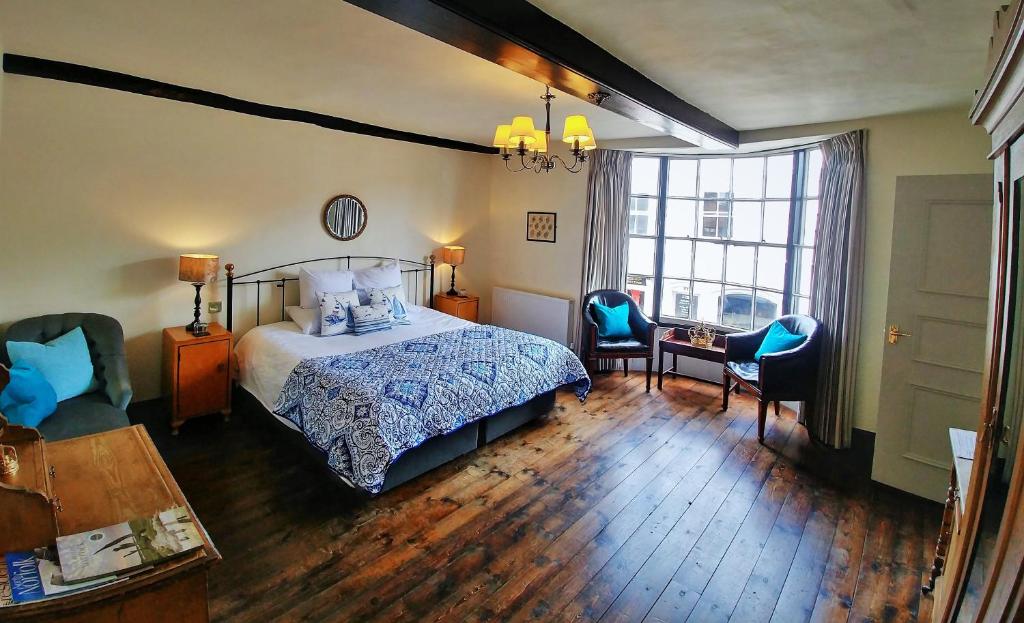 a bedroom with a bed and a table and chairs at Kings Head Holt in Holt