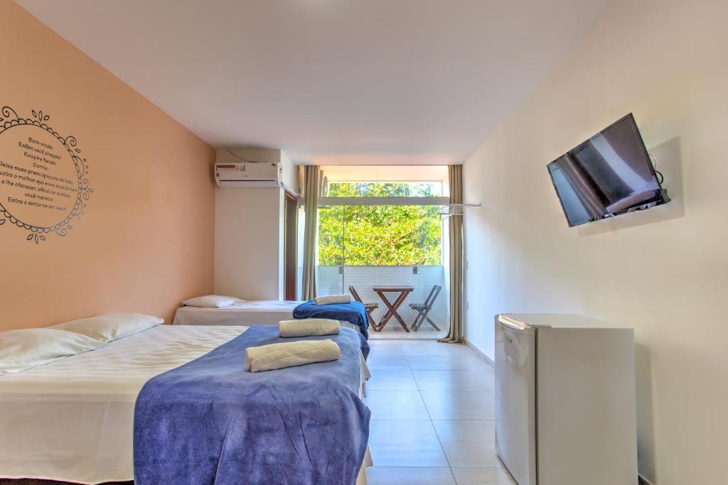 1 dormitorio con 2 camas y TV en la pared en Pousada Recanto Barra da Tijuca, en Río de Janeiro