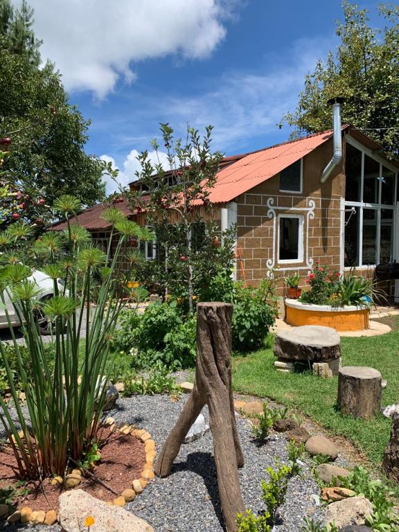 a garden in front of a brick house at Cabañas Los Abuelos in Zacatlán