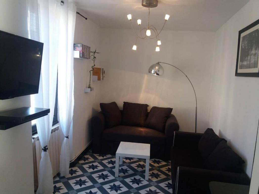 ein Wohnzimmer mit einem Sofa und einem Tisch in der Unterkunft T2 tout confort avec terrasse in Cransac