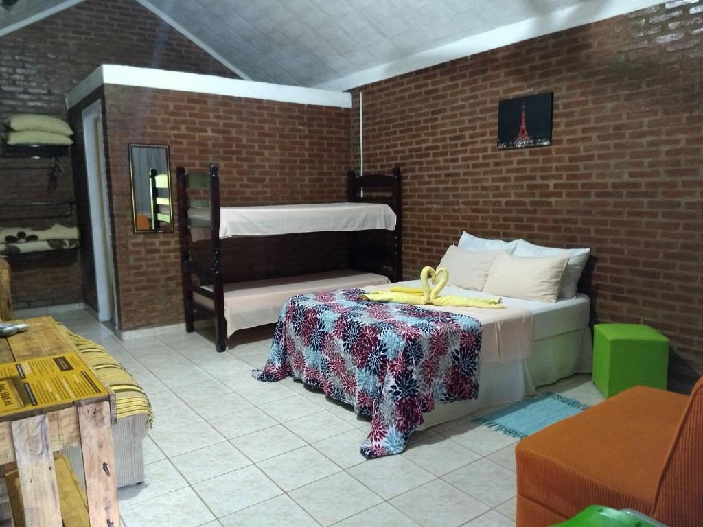Un dormitorio con una cama y una mesa con un arco. en Pousada & Pesca Esportiva Fazolin, en Socorro
