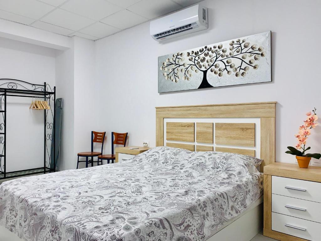 1 dormitorio con 1 cama con una foto de árbol en la pared en Casa Sergio de Novelda, en Novelda