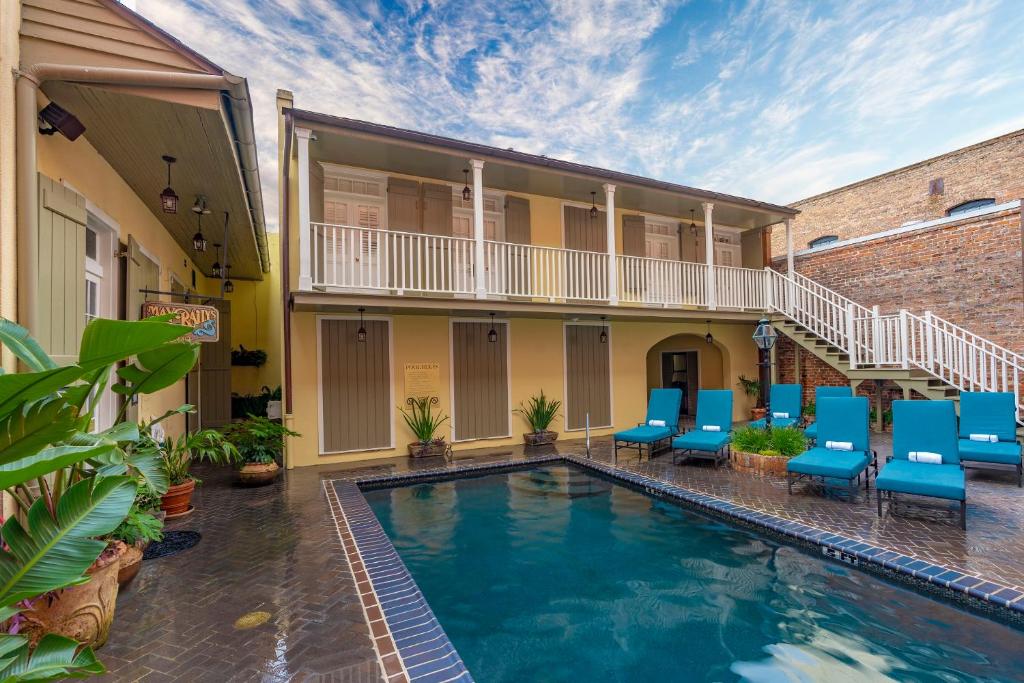 a swimming pool with blue chairs in front of a building at Dauphine Orleans Hotel in New Orleans