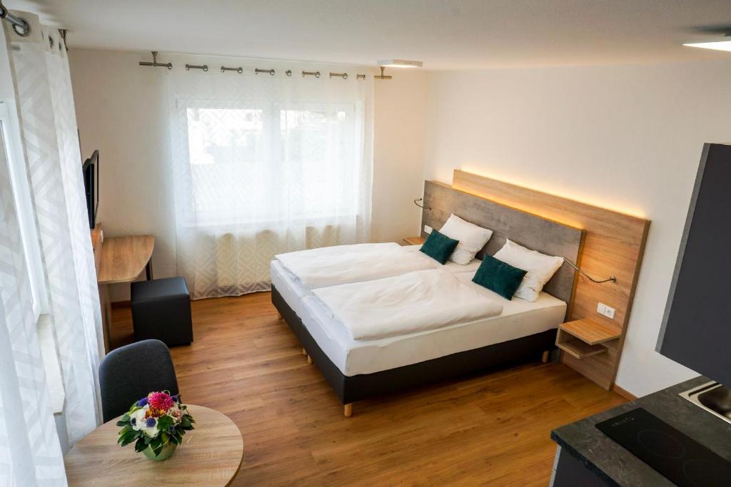 ein kleines Schlafzimmer mit einem Bett und einem Tisch in der Unterkunft SP-Appartements in Neuhausen auf den Fildern