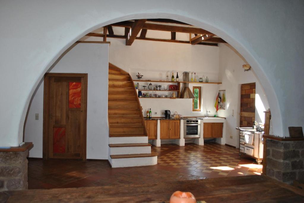 a kitchen with an archway and a staircase in a house at Maison Pittoresque in Hermerswiller