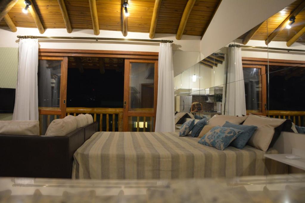 um quarto grande com uma cama e um sofá em Lofts Asa Delta em Ilhabela