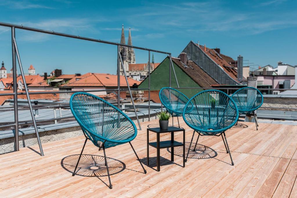 three chairs and a table on a roof at Hotel Weidenhof in Regensburg