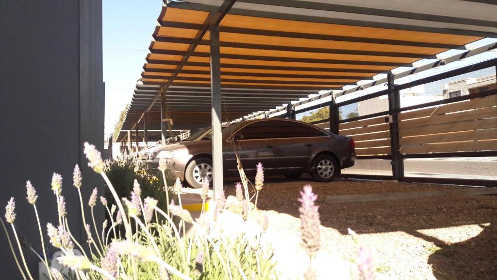 un coche aparcado bajo un aparcamiento con garaje en "EXCEPCIONAL 18" DEPARTAMENTO CON COCHERA - Vista a la MONTAÑA en Mendoza