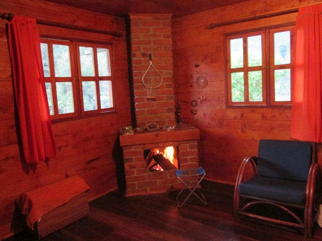 a living room with a brick fireplace and a chair at Termales Cabaña en Santa Rosa de Cabal in Santa Rosa de Cabal