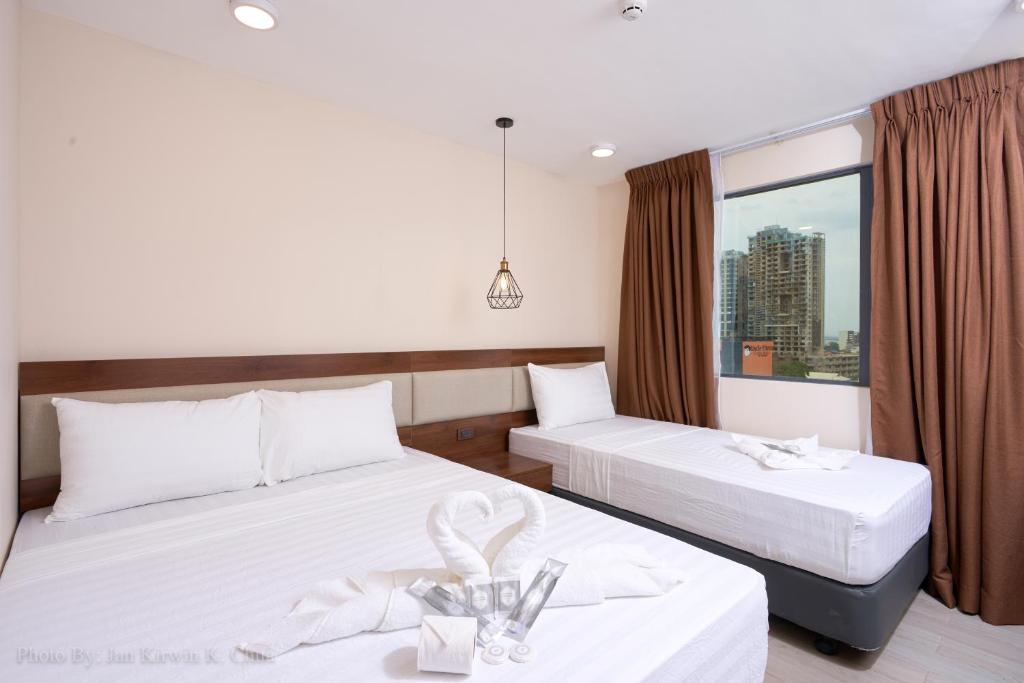 a hotel room with two beds and a window at Griffin Hotel and Suites in Cebu City