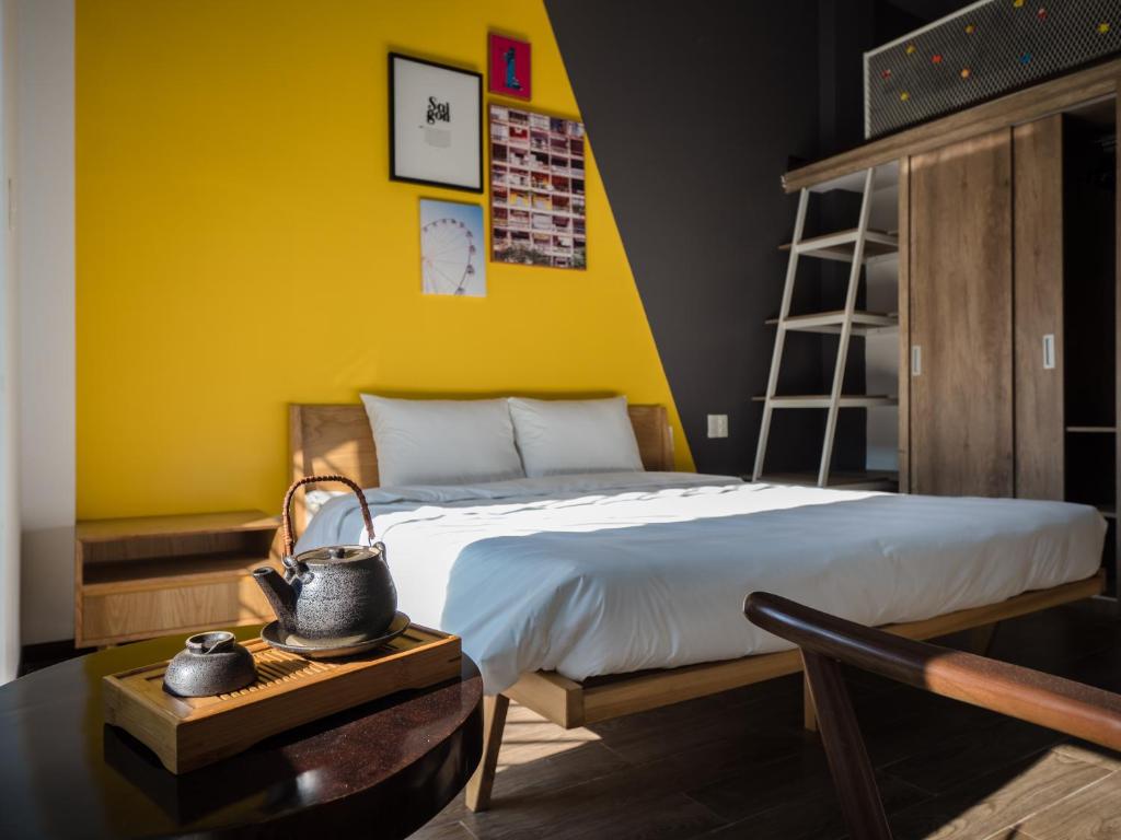a bedroom with a bed with a yellow wall at Wings House in Da Nang