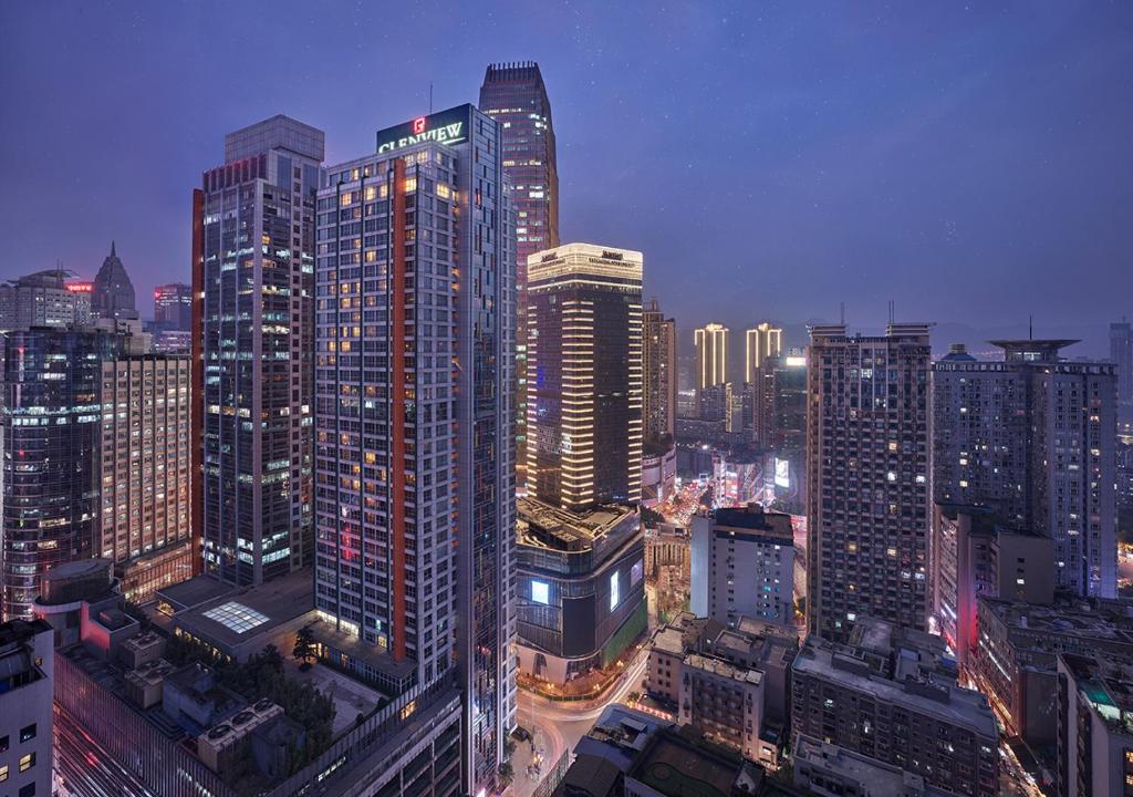 Glenview ITC Plaza Chongqing في تشونغتشينغ: أفق المدينة في الليل مع المباني الطويلة