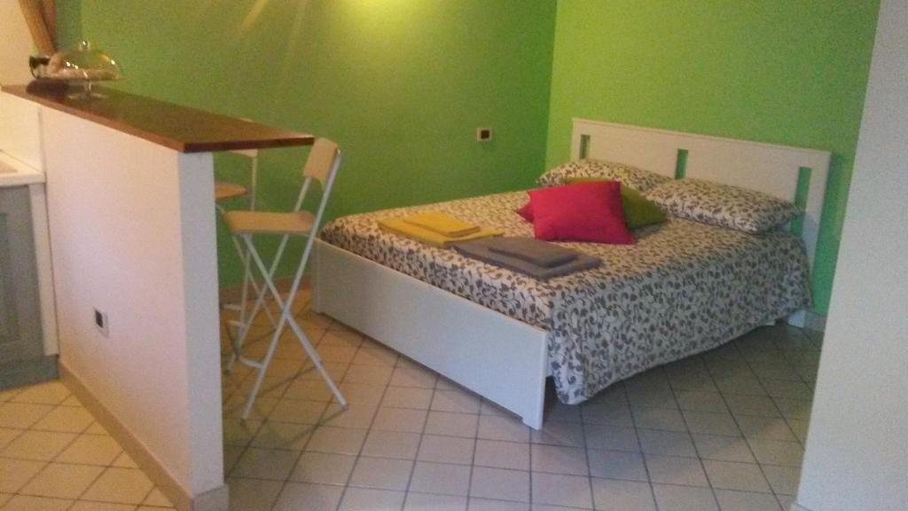 um quarto com uma cama e paredes verdes em appartamento turistico il colle del nibbio em Torricella Peligna