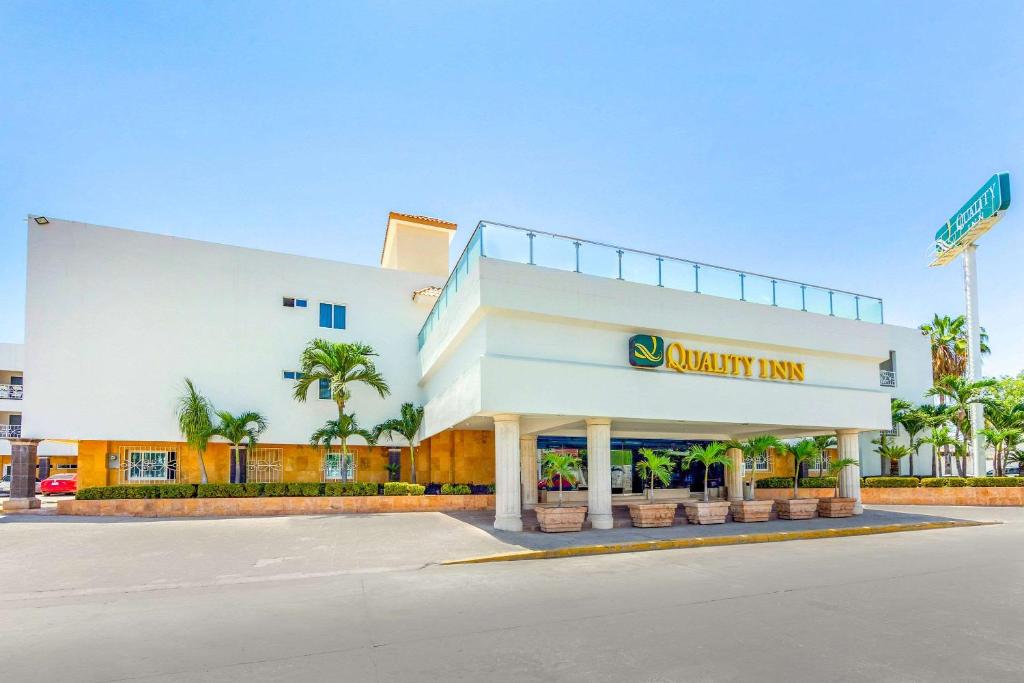 a white building with a synergy inn sign on it at Quality Inn Mazatlan in Mazatlán