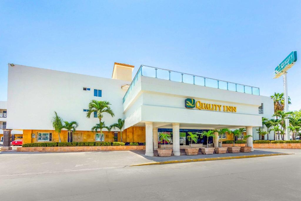 - un bâtiment blanc avec un panneau synergique d'auberge dans l'établissement Quality Inn Mazatlan, à Mazatlán