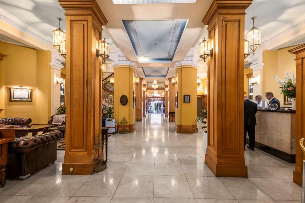 a hallway in a building with columns and a lobby at Castlereagh Boutique Hotel, Ascend Hotel Collection in Sydney