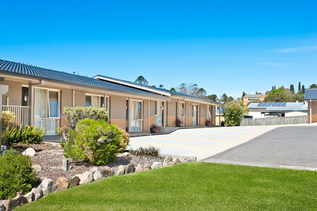 a row of houses with a driveway and grass at Bega Village Motor Inn in Bega