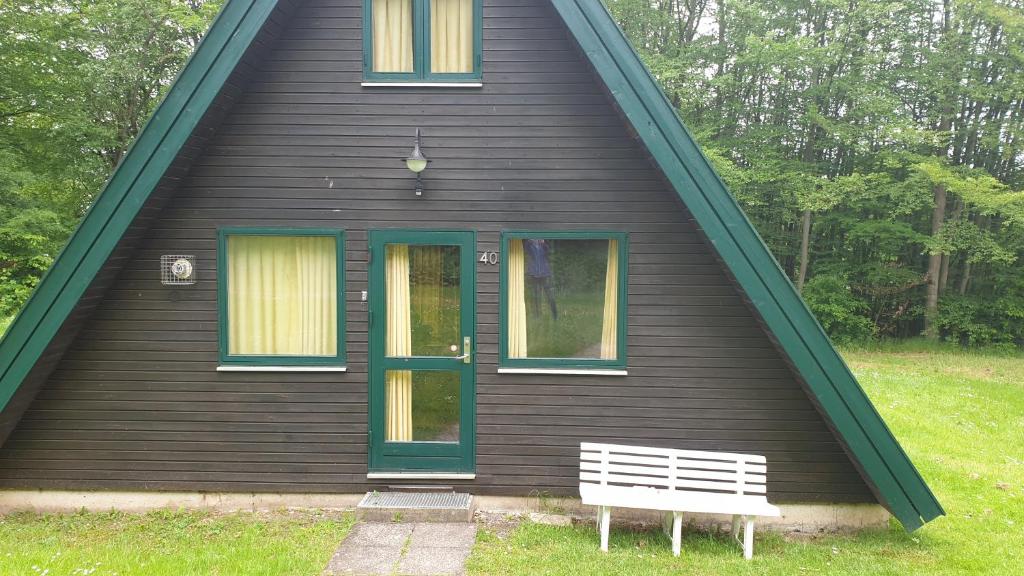 a house with a bench in front of it at Ferienhaus Nr. 40 im Ferienpark am Twistesee in Bad Arolsen