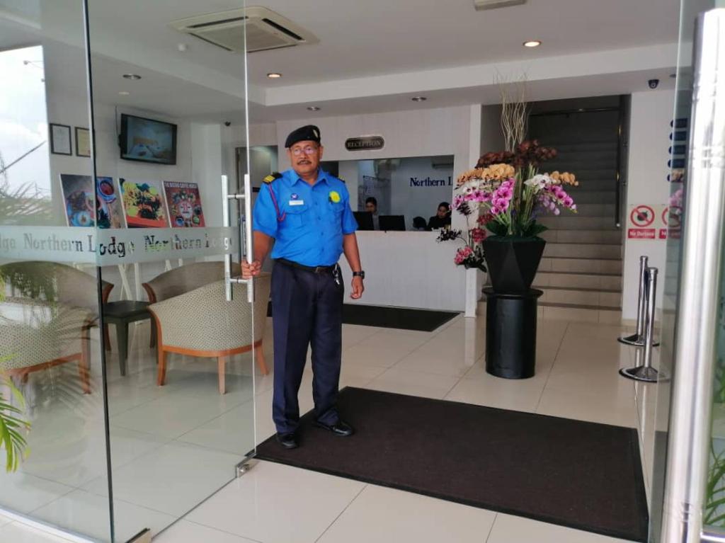 a police officer standing in the lobby of a building at Northern Lodge Hotel in Sungai Petani