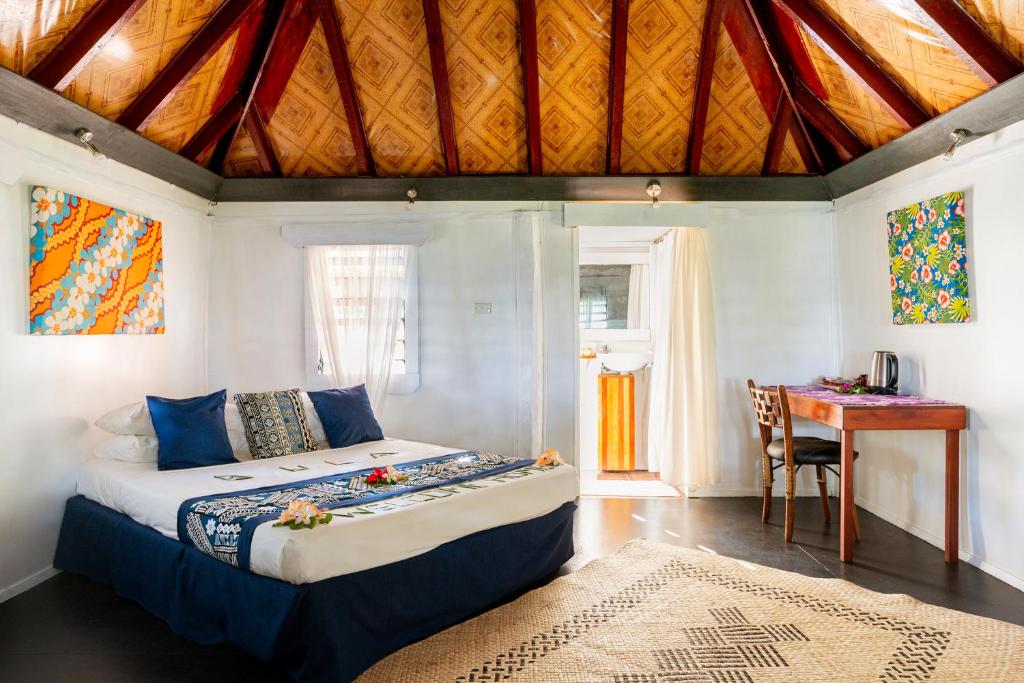 a bedroom with a bed and a table with a desk at Belo Vula Island Resort Limited in Lautoka
