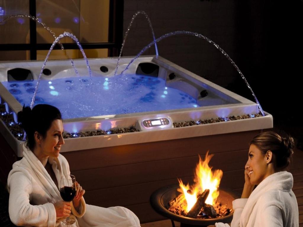 dos mujeres sentadas frente a un jacuzzi en B&B Palazzo Diaz, en Marsala