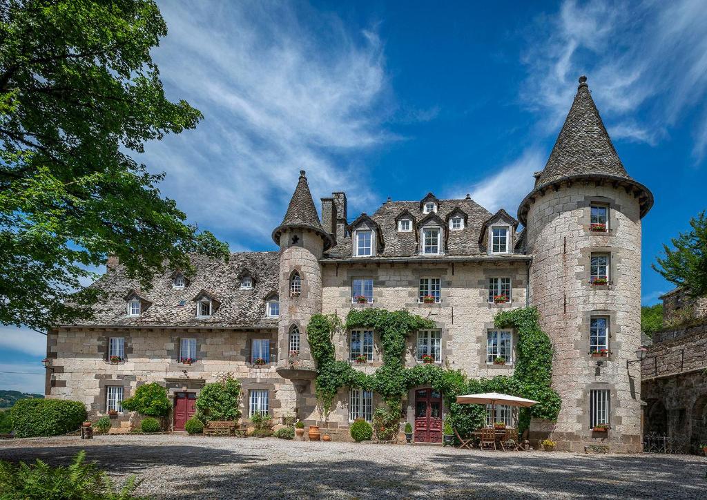un gran castillo de piedra con dos torres en Chateau De Courbelimagne, Raulhac, en Raulhac