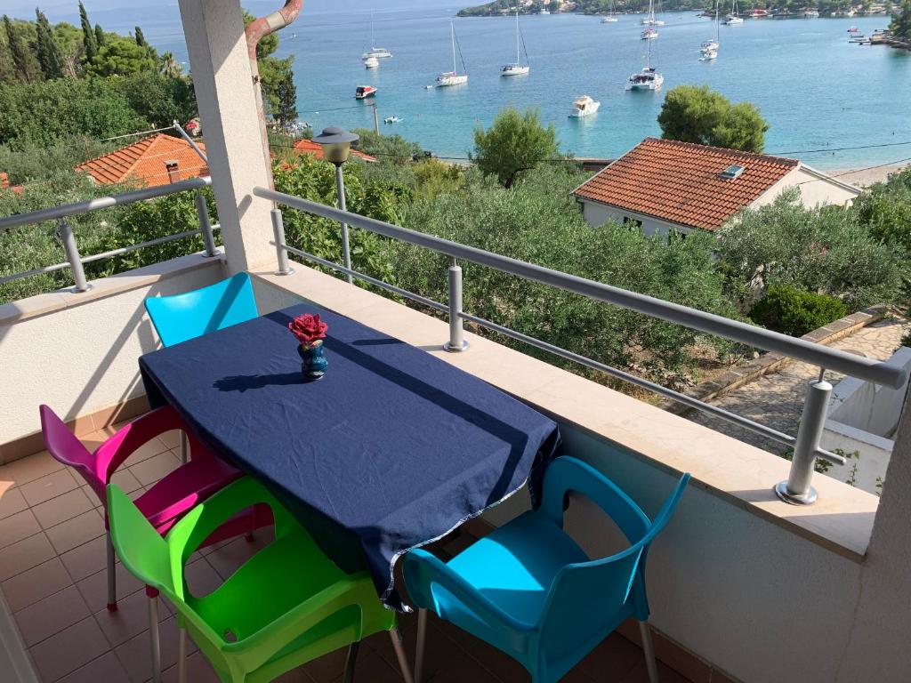 a table and chairs on a balcony with a view of the water at Apartment Excellent in Nečujam