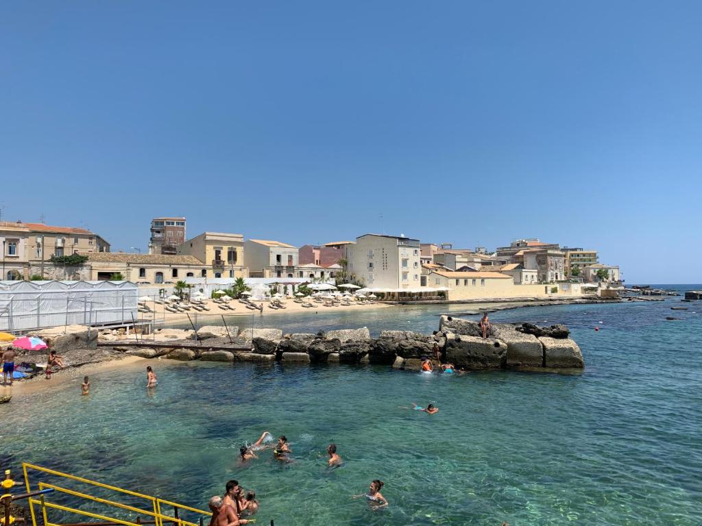 un grupo de personas en el agua en una playa en Populus, en Siracusa